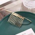 Elegante pettine per capelli in metallo dorato con trama a onde su piatto verde - Oro