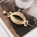 Elegante pasador de pelo de metal dorado con detalle de corazón y marco ovalado - Decoración de Corazón Dorado