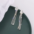 Elegant silver tassel earrings with heart-shaped crystal rhinestones on a green ceramic plate - Pointed Heart (C3507) / Silver
