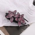 Dettaglio di fermaglio per capelli con doppi fiori di strass rosa su sfondo bianco - Rosa Rosso + Rosa