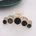 Retro clear acrylic hair claw with five gold-rimmed black circular accents on grey background - Brown Base Black(C5106)
