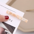 Detailed macro view of an orange marble acetate hair clip with a metal duckbill base - Light Pink Style (B7123)