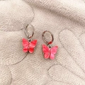Boucles d'oreilles papillon en acétate rose avec créoles argentées sur fond en tissu - Rose rouge
