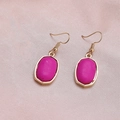 Detail of elegant gold hook earrings with rose red oval stone on pink silk fabric - Rose Red