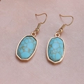 Macro shot of gold drop earrings with oval blue faux turquoise stone in vintage style - Light Blue Floral