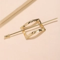 Dettaglio di un fermaglio geometrico dorato con cornice metallica lucida a onde - Stile Bastone Rettangolare Oro