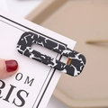 Close-up of a hollow rectangular acetate hair clip with black and white marble patterns - Black Leopard