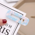 Detail view of blue and pink marble acetate hair clip with golden metal clip on card - Light Blue