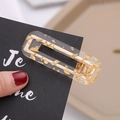 Detailed close-up of a rectangular marble acetate hair clip with gold foil flakes decoration - Gold Foil