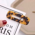 Dettaglio di un fermaglio per capelli in acetato tartarugato con molla dorata - Leopardo Caffè Scuro