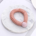Pink spiral telephone wire hair tie with decorative bead on marble surface - Pink (K8105)