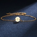 Golden delicate chain bracelet featuring a polished round pendant with engraved letter Q - Letter Q
