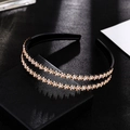 Close-up of sparkling champagne rhinestones in floral patterns on a black double-layer headband - Champagne Headband