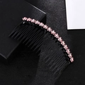 Detailed macro view of pink rhinestone flower embellishments on a black plastic hair comb - Pink Hair Comb