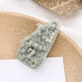 Detalle de la pinza para el pelo de lana de cordero verde claro sobre un plato - Verde Menta (E6205)