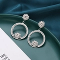 Macro-weergave van de zilveren oorringen met bloemkristallen op donkergroene zijden stof - Zilver (A8322)