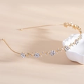 Goldenes Blumen-Stirnband mit Strasssteinen und floralem Blattdesign auf beigem Grund - Strass Gold (C9229)