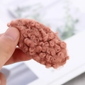 Vue détaillée d'une pince à cheveux en peluche marron-rose avec texture de laine bouclée - Beige