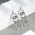 Dettaglio di orecchini a pendente argento con cifre 520 nere e strass bianchi incastonati - 520 Argento + Nero