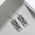 Detail der LOVE Ohrhänger aus Silberlegierung mit schwarzer Emaille und Strasssteinen - LOVE Silber + Schwarz