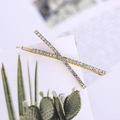 Elegant pair of gold-tone hair clips with sparkling rhinestones in a cross pattern - White