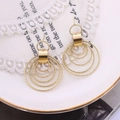 Elegant gold multi-layer textured hoop earrings displayed on white lace and ceramic - Gold