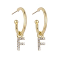 Detailed view of gold hoop earrings with sparkling crystal-encrusted letter F pendant - Letter F / Gold