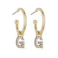Detail of gold hoop earrings with sparkling crystal-encrusted letter G pendant charms - Letter G / Gold
