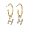Detailed view of gold earrings with H letter pendants and sparkling micro-pave zircons - Letter H / Gold