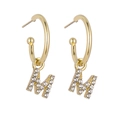 Golden letter M earrings with sparkling rhinestones on a white background for women - Gold M