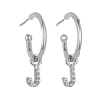 Close-up of silver hoop earrings with sparkling crystal-encrusted letter J pendant charms - Silver J