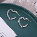 Gros plan de boucles d'oreilles cœur argentées avec texture métallique froissée unique - Style Cœur (A7416) / Argent