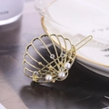 Détail de la pince à cheveux coquillage dorée avec perles et strass sur plat en céramique - Style Perle Coquille (C2515)