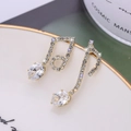 Elegant gold music note earrings with sparkling crystals displayed on a porcelain plate - Gold
