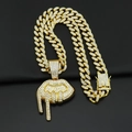 Gros plan d'une chaîne cubaine dorée avec strass et pendentif en forme de lèvres coulantes - Pendentif Or avec Chaîne Cubaine Diamantée 45CM