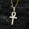 Iced out gold Ankh cross pendant necklace with sparkling zircons on black rock background - Gold
