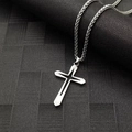Colgante de cruz estrella hueca en acero inoxidable pulido con cadena de trigo en fondo oscuro - Cruz de Luz Estelar Cadena Spiga