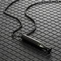 Macro shot of black stainless steel cylindrical whistle pendant necklace on textured surface - Black Bead Chain