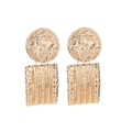 Detailed view of vintage gold coin earrings with embossed patterns and hammered texture - Gold