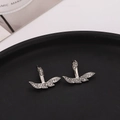 Macro shot of silver leaf earrings with rhinestone pave setting on a black surface - Silver