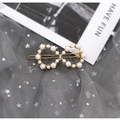 Elegant gold bow-shaped hair clip with white pearls and rhinestones on grey starry tulle - Infinity Shape