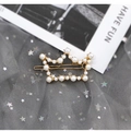 Elegant gold crown hair clip with white pearls for women on a grey star mesh background - Crown