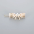 Elegante fermaglio per capelli in lega dorata con perle bianche a forma di fiocco chic - Stile Fiocco (B8431)