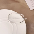 Detail of silver oval geometric hair clip on a white ceramic plate with fabric background - Silver (B7335)