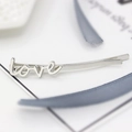 Minimalist silver LOVE letter hair clip with polished alloy finish on white background - Silver LOVE Design
