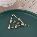 Detailaufnahme der geometrischen Haarspange in Dreiecksform mit Pfeil-Design in Gold-Optik - Gold