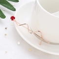 Elegante fermaglio per capelli ondulato oro rosa con una grande gemma rossa su piatto ceramico - Rosso