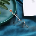 Detail view of a rose gold spiral hairpin with a brown gemstone on velvet background - Champagne