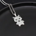 Close-up of polished silver stainless steel cartoon wolf pendant on a textured black plate - Brave Cat