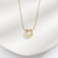 Primer plano de colgante en U dorado con cadena de serpiente y fondo ondulado - Dorado